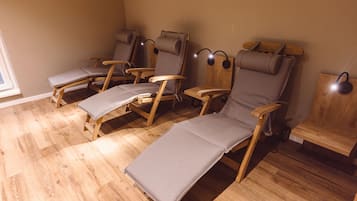 Relax in comfort with lounge chairs and a small table, set against a simple backdrop.