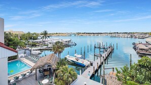 A marina with boats docked, a swimming pool, and a docked yacht. - Waterfront Dock Pool Condo Near Duval St Pet OK (Key West)