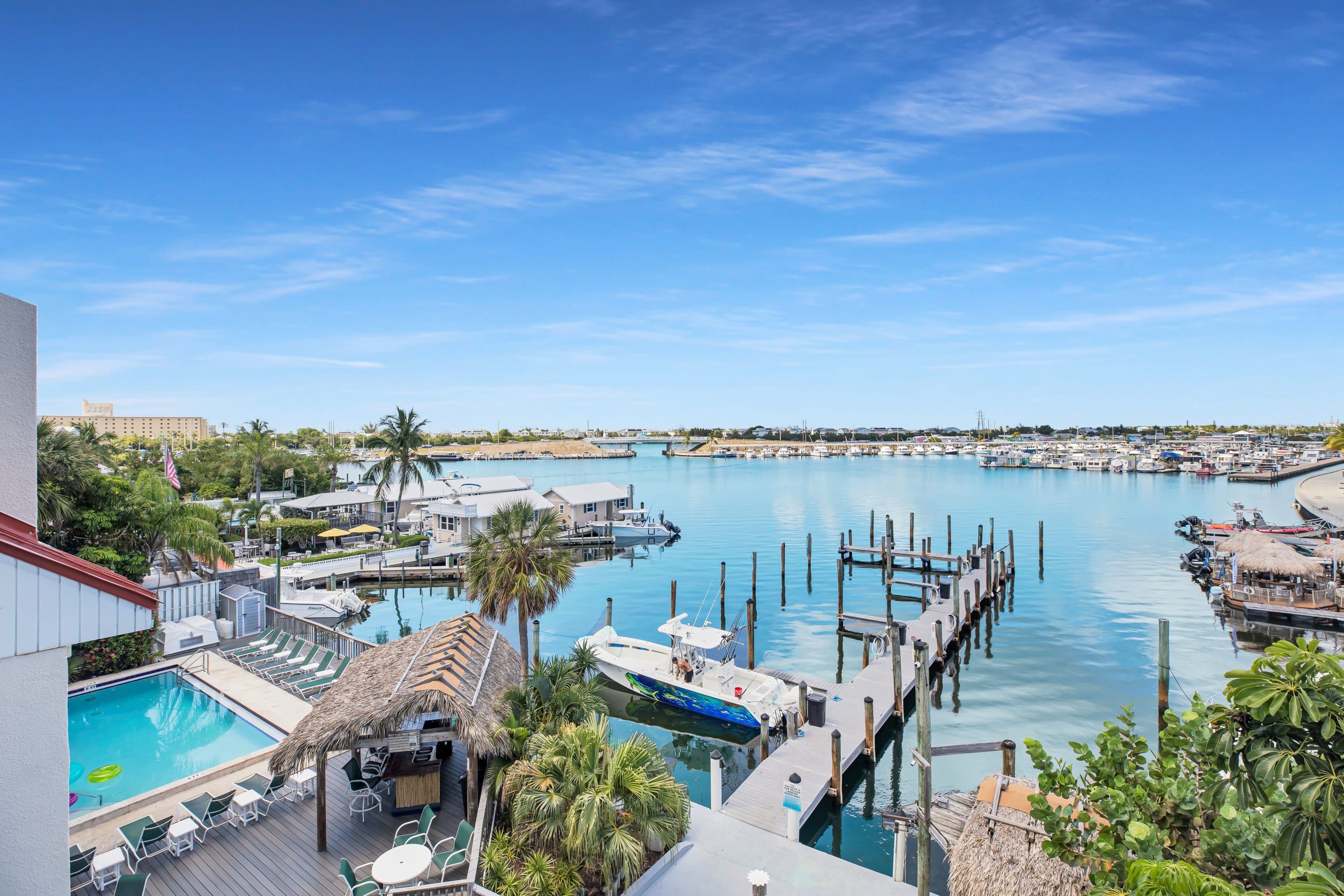 A marina with boats docked, a swimming pool, and a docked yacht.