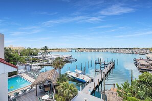 A marina with boats docked, a swimming pool, and a dock extending into the water. - Waterfront Dock Pool Condo Near Duval St Pet OK (Key West)