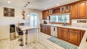 A modern kitchen with wooden cabinets, a marble countertop, and a built-in oven. - Near Yale & Lighthouse Point Beach: Home w/ Pool! (New Haven)