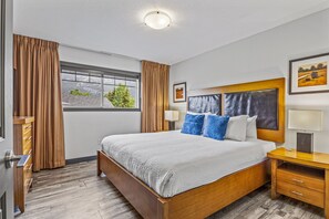 Relax in a spacious room with a large bed, bedside tables, and a window with curtains.