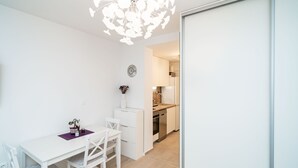 Une cuisine moderne avec des meubles blancs, un plan de travail en bois et un four encastré.