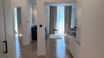 Un appartement moderne et bien éclairé, doté de planchers en bois franc, d’une cuisine avec coin repas et d’un espace de vie agrémenté d’une grande fenêtre.