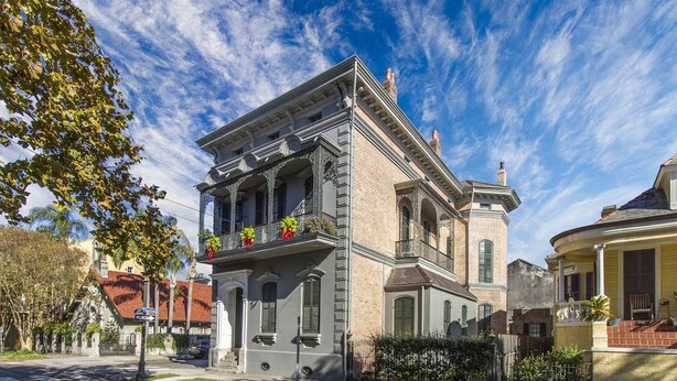 A historic building with a symmetrical facade, a central entrance, and a balcony with flowers. - Lanaux Mansion - Beth's Escape with Courtyard Balcony (New Orleans)