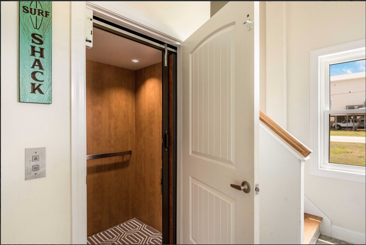 A hotel room with a wooden door, a small window, and a view of the outside.