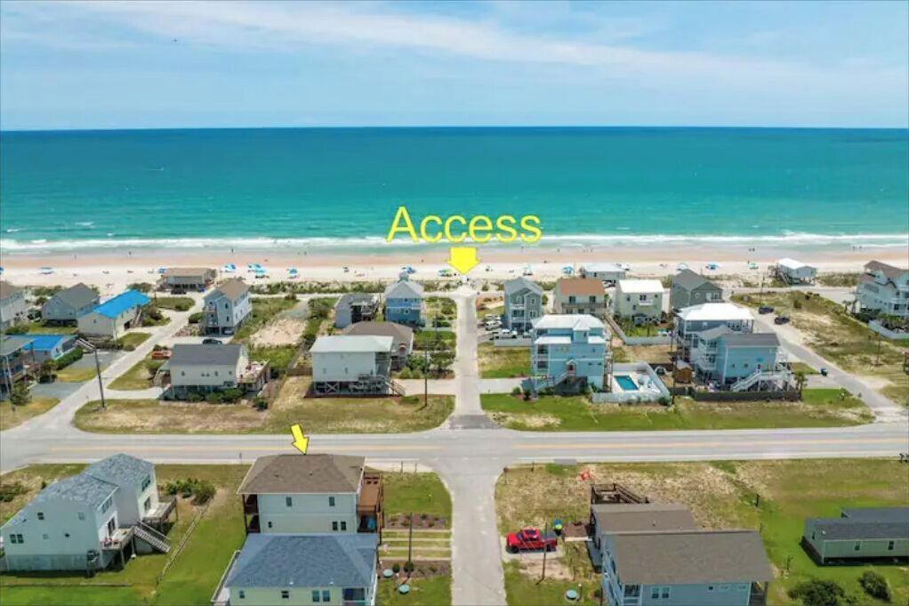 Une zone résidentielle côtière comprenant des maisons, une plage et une route menant à la plage.