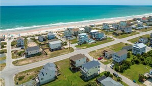 Un área residencial costera con casas, una playa y una carretera.