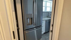 A modern kitchen with a stainless steel refrigerator and a water dispenser. - Close to everything (Newport)