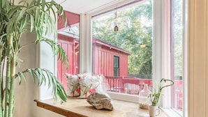Ein Fensterbrett mit einem Blumentopf, einem Stein und einer kleinen Vase mit Pflanze.
