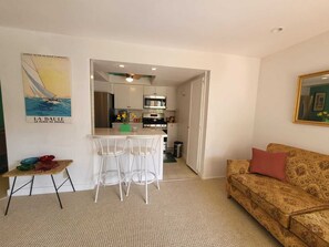 Cozy living space with a kitchenette, dining table, and sofa, perfect for a compact retreat.
