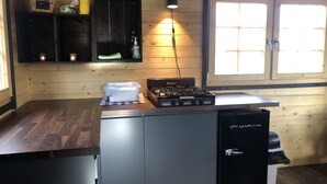 A compact kitchen with a gas stove, a built-in oven, a sink, and a window with natural light.