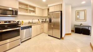 A modern kitchen with stainless steel appliances, a dishwasher, and a built-in microwave. - Peninsula 12, 𖠁 3Bdr Lux Beach condo 𖠁Pools 𖠁Rooftop 𖠁Gym 𖠁 (Playa Langosta)