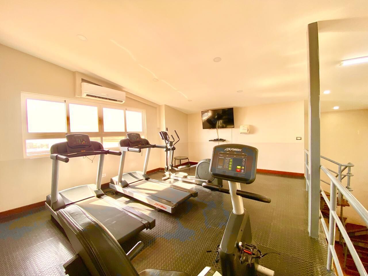 A fitness room with treadmills, a stationary bike, and a rowing machine.