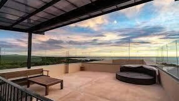 A spacious outdoor terrace with a wooden bench and a circular seating area, overlooking a scenic landscape. - Peninsula 12, 𖠁 3Bdr Lux Beach condo 𖠁Pools 𖠁Rooftop 𖠁Gym 𖠁 (Playa Langosta)