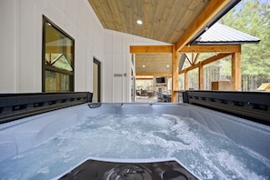 A hot tub area with wooden beams and a view of the outdoors.