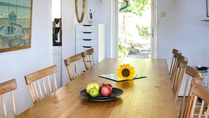 A dining table with a bowl of fruit and a sunflower centerpiece. - Beautiful home in Nybrostrand with WiFi (Nybrostrand)