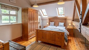Een slaapkamer met een houten bed, twee nachtkastjes, een kledingkast en een dakraam.