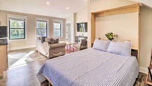 Un dormitorio amplio con una cama grande, un escritorio y un sofá.