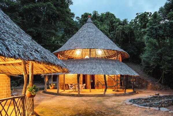 Guests can relax in a central communal space surrounded by a natural environment.