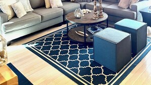 A modern living room with a sectional sofa, a round coffee table, and a chandelier. - Enjoy Fall Foliage in Renov End Unit Townhouse with Fireplace (Dover)