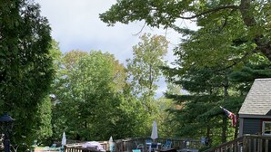 A wooden deck with outdoor seating, a pool, and a flag. - Enjoy Fall Foliage in Renov End Unit Townhouse with Fireplace (Dover)