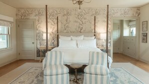 A bedroom with a large bed, two upholstered chairs, a small round table, and a chandelier. - Main Residence: 5 beds, 5 baths, sleeping porches, & full kitchen. (Medford)