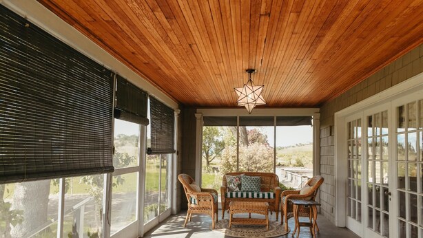 A covered porch with wicker furniture, large windows, and a wooden ceiling. - Main Residence: 5 beds, 5 baths, sleeping porches, & full kitchen. (Medford)