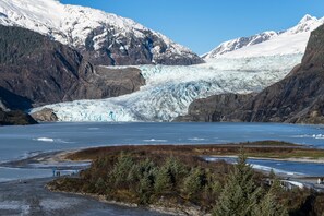 Un ghiacciaio con vista chiara sulle montagne circostanti e una piccola isola dalla vegetazione rada.