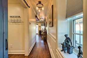 Enter a hallway leading to a room with a window, featuring a coat rack and a sculpture.