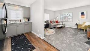 A modern apartment with a kitchen, living room, and dining area. - Downtown Wyandotte, Clean and Cozy! (Wyandotte)
