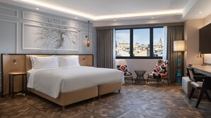 A hotel room with a large bed, a view of the city, a desk, and a chair. - Burdock Hotel Istanbul, Autograph Collection (Istanbul)