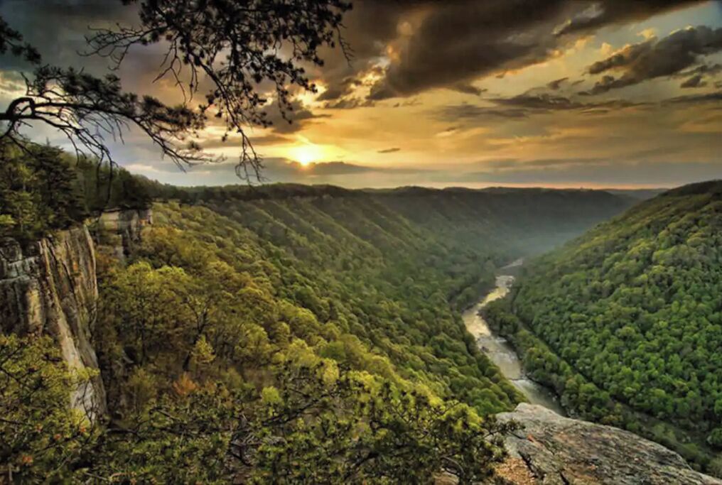 A mountainous landscape with dense forest and a river.