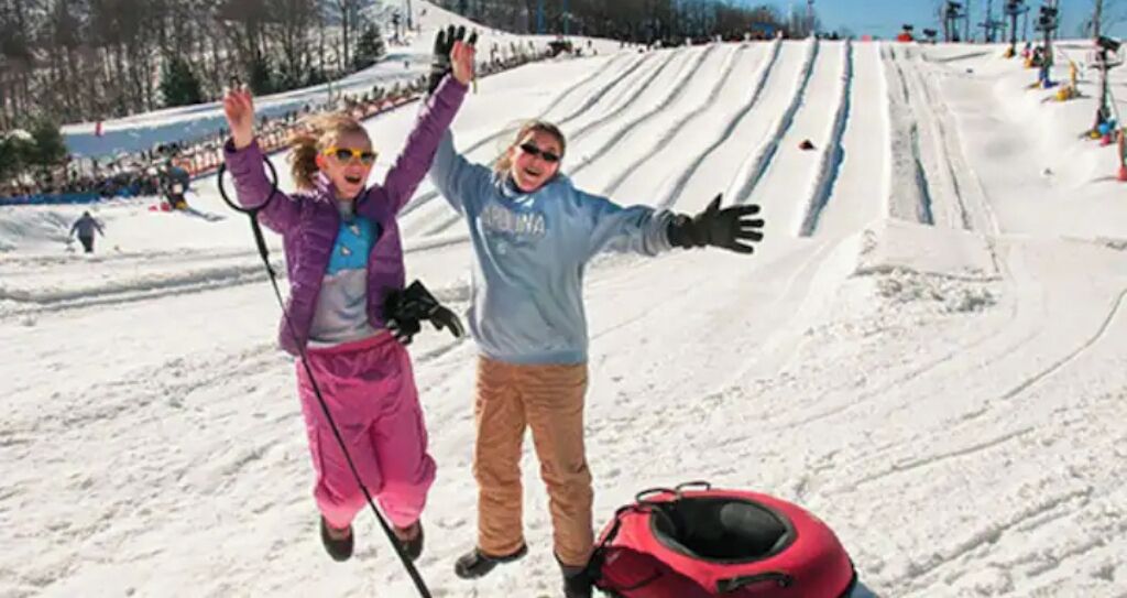 Pista de esquí nevada con personas esquiando y de pie.