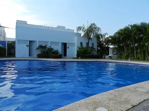 Ein Schwimmbecken mit einem modernen Gebäude im Hintergrund.