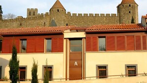 A building with a large stone castle in the background, featuring two prominent towers.