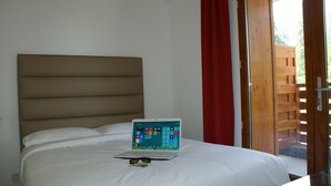 A bed with a laptop, white bedding, and a red curtain. - Escapade de Ski à Valberg av/Vues des Montagnes! (Guillaumes)