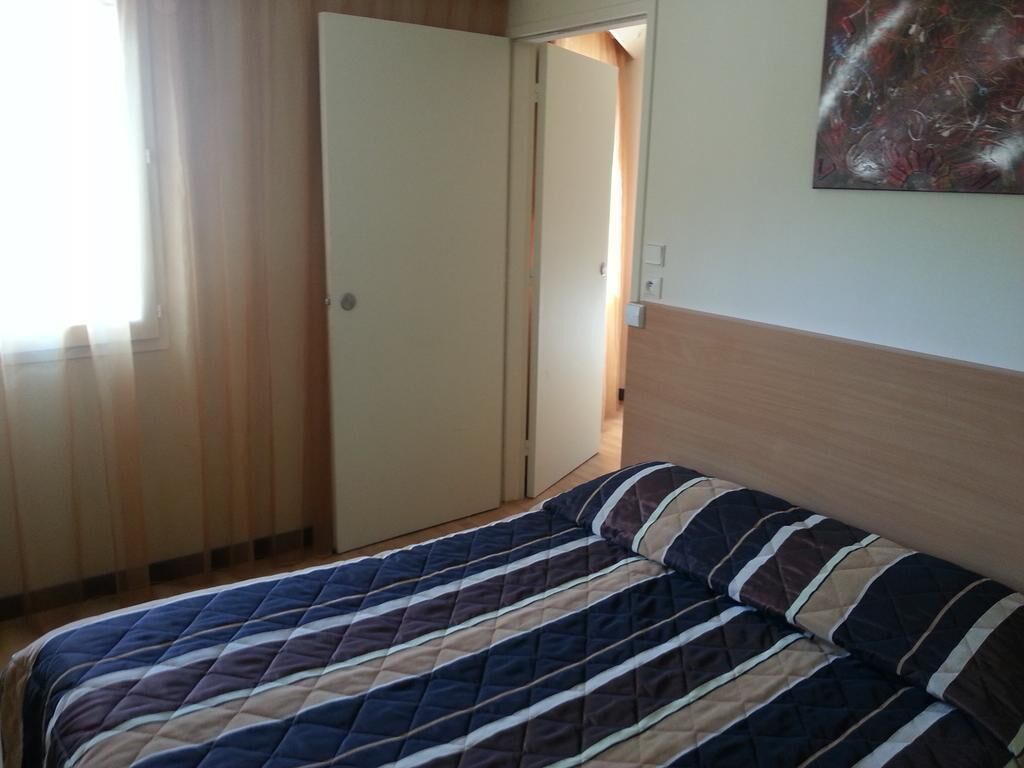 Un dormitorio con cama, armario y un cuadro en la pared.