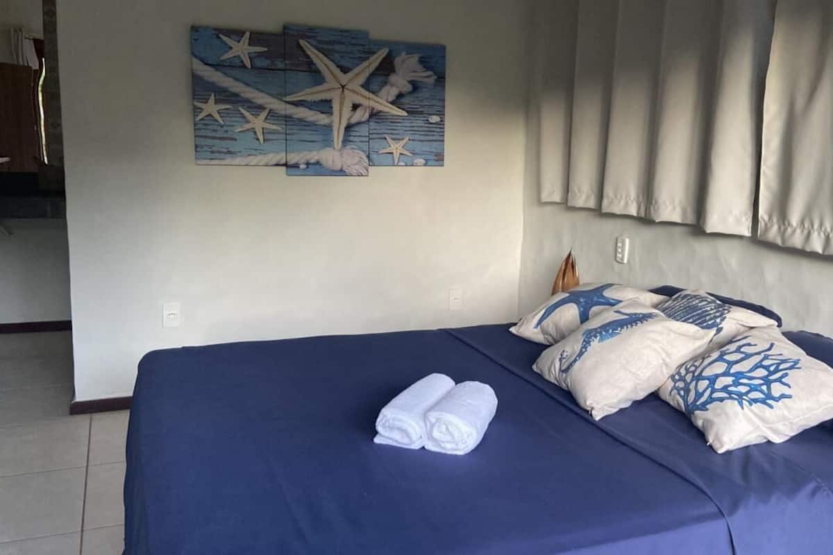Une chambre avec un lit, des serviettes et un élément décoratif mural.