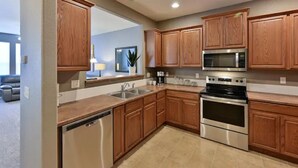 A modern kitchen with wooden cabinets, stainless steel appliances, and a dishwasher. - Colorado comfort, in a great location with monthly discounts. (Monument)