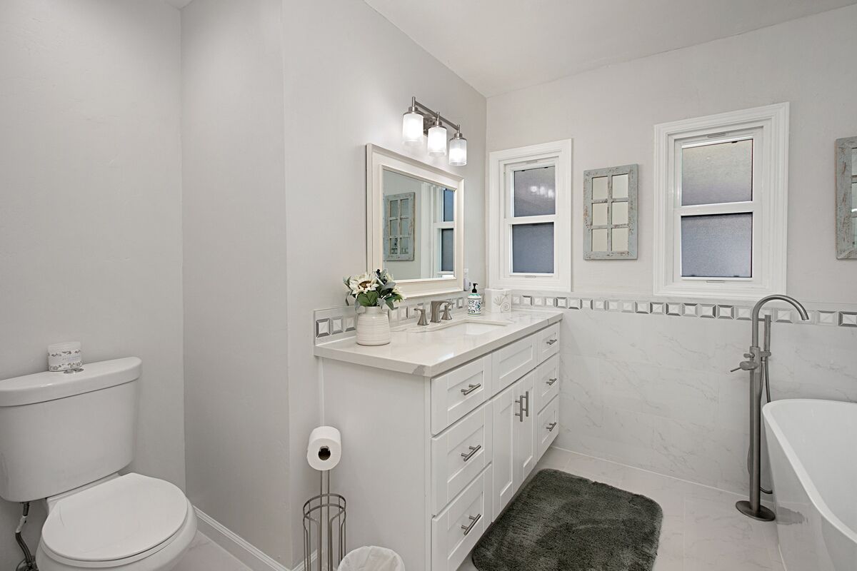 A modern bathroom with a toilet, sink, and bathtub.