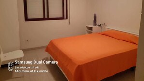 Una camera da letto con un letto, un comodino, una finestra e una porta.