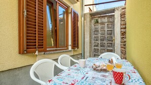 A table set for two with a tablecloth featuring nautical designs, a red heart-patterned mug, and a plate of desserts. - Gorgeous home in Susak with WiFi (Susak)