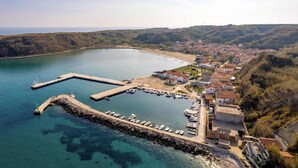 An aerial view of a coastal town with a marina, houses, and a hilly landscape. - Gorgeous home in Susak with WiFi (Susak)