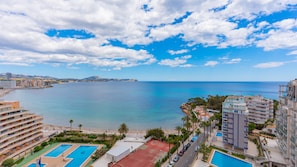 Et kysthotel med flere swimmingpools, en strand og havudsigt.