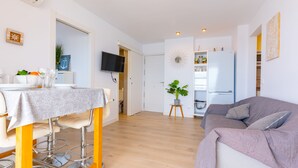 A modern apartment with a dining area, a living room, a kitchen, and a TV. - 11F 2 Dormitorios con Vistas al mar (Calp)