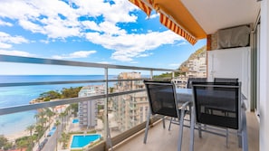 A balcony with a view of the sea and buildings, a pool, and outdoor furniture. - 11F 2 Dormitorios con Vistas al mar (Calp)
