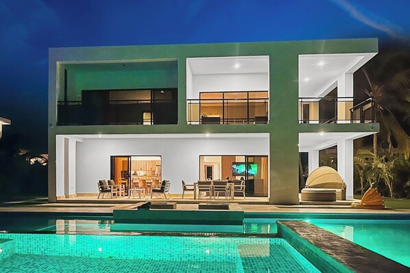 Una casa moderna de dos pisos con piscina delantera.