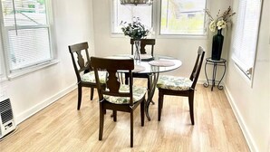 A dining area with a round table, four chairs, and a vase with flowers. - Cozy retreat, near some of the best Florida beaches! (Bradenton)