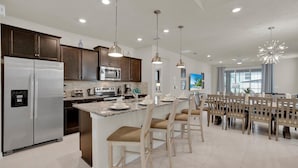 A modern kitchen with stainless steel appliances, granite countertops, and pendant lighting.